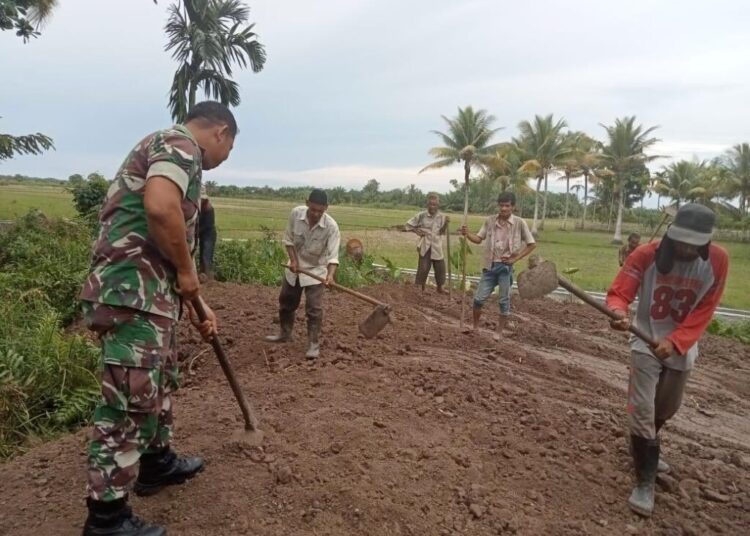 Babinsa Kodim Aceh Utara Gotong Royong dengan Warga Timbun Jalan Kuburan