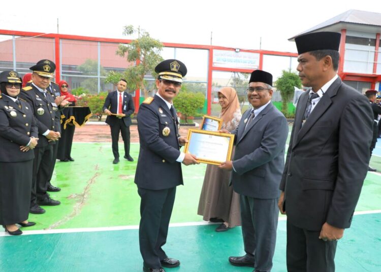 Kakanwil Kemenkumham Aceh Dr Meurah Budiman MH, menyerahkan penghargaan Indeks Reformasi Hukum (IRH) tahun 2024 kepada Penjabat Bupati Aceh Utara Dr Mahyuzar MSi, pada upacara peringatan Hari Pengayoman ke-79 tahun 2024 di Lapas Kelas IIA Banda Aceh