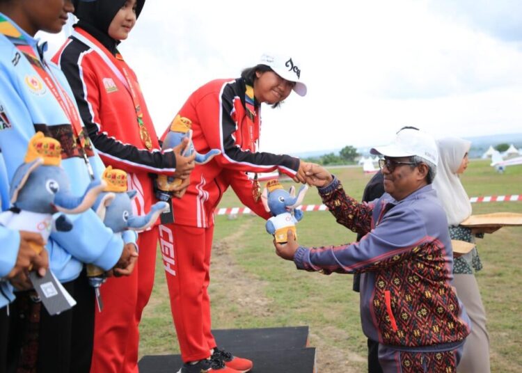 Penjabat Bupati Aceh Utara Dr Mahyuzar MSi, melakukan pengalungan medali untuk atlet Aceh peraih emas pada mata lomba duration flight dual seater beregu putri Cabor Terbang Layang Pekan Olahraga Nasional (PON) XXI Aceh-Sumut tahun 2024.