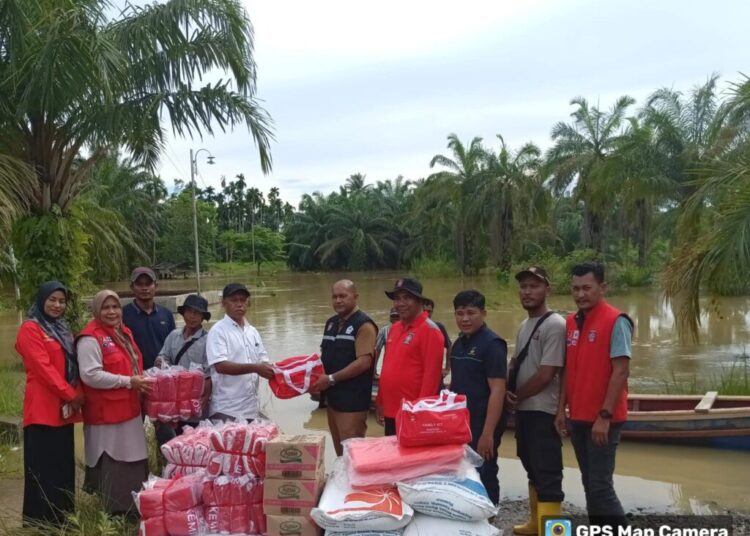 Kepala Dinas Sosial PPPA Aceh Utara Iskandar SSTP MSP, menyerahkan bantuan masa panik untuk korban banjir di Gampong Lawang, Kecamatan Matangkuli, Selasa (8/10/2024).