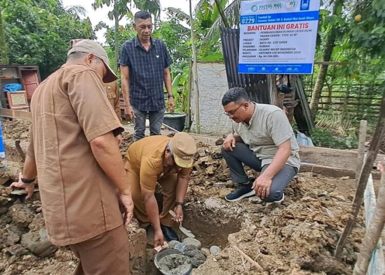 Penjabat Bupati Aceh Utara Dr Mahyuzar MSi, melakukan peletakan batu pertama pembangunan rumah layak huni tahan gempa di Kecamatan Cot Girek, Senin (14/10/2024).