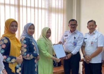 Ketua Dekranasda Aceh Utara, Ny. Awirdalina Mahyuzar, saat menerima sertifikat Hak Kekayaan Intelektual (HAKI) Kasab Bule Jok, sebuah kerajinan tradisional warisan budaya dari Gampong Keutapang, Kecamatan Tanah Pasir. Foto: Humas