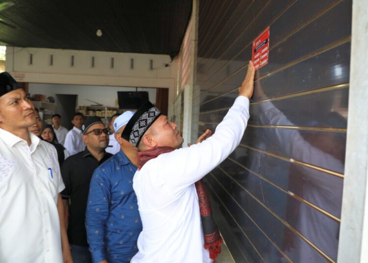 Bupati Ayahwa Tempel Stiker Nomor Telepon Penting Secara Simbolis di Rumah Warga