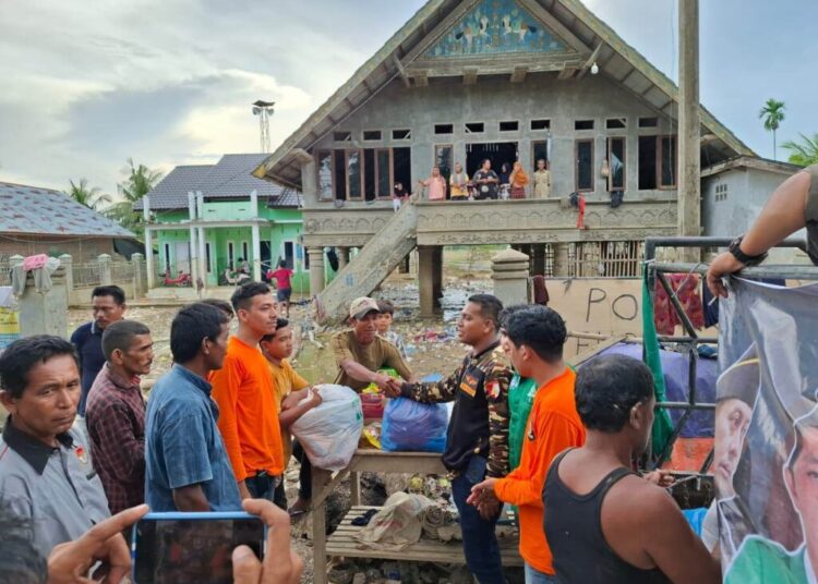 Ketua PC GP Ansor Aceh Utara, Adni Fajri, bersama Tim Bagana menyerahkan bantuan logistik kepada pengungsi korban banjir di posko pengungsian Desa Geulumpang Bungkok, Kecamatan Baktiya, Sabtu (13/12).