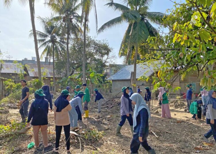 Mahasiswa KKN Unimal Kelompok 06 bersama TNI dan perangkat desa bergotong royong membersihkan lahan Huntara di Desa Mane Tunong, Muara Batu, Aceh Utara