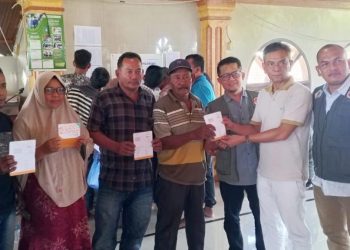 Pelaksana Tugas Kalaksa BPBD Aceh Utara, Fauzan, menyerahkan bantuan stimulan perbaikan rumah BNPB kepada warga terdampak banjir di Kecamatan Sawang, Aceh Utara