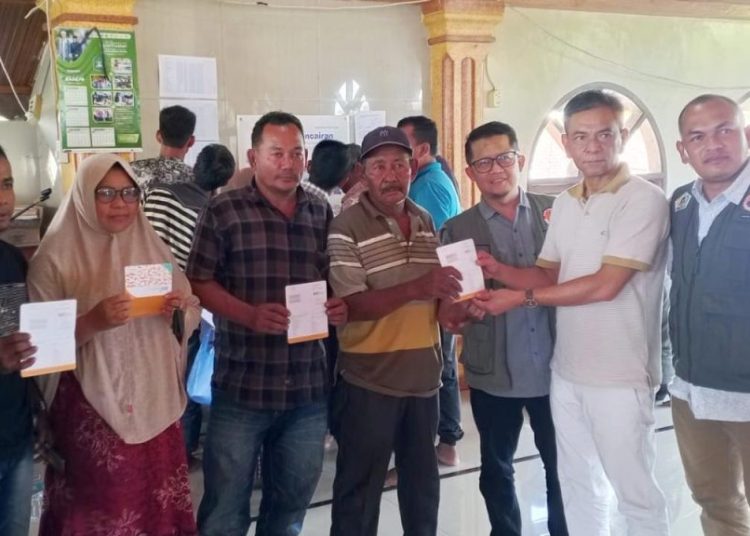 Pelaksana Tugas Kalaksa BPBD Aceh Utara, Fauzan, menyerahkan bantuan stimulan perbaikan rumah BNPB kepada warga terdampak banjir di Kecamatan Sawang, Aceh Utara