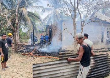 Petugas bersama warga saat memadamkan sisa api yang menghanguskan satu unit rumah di Gampong Cot Laba, Baktiya Barat, Aceh Utara