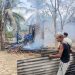 Petugas bersama warga saat memadamkan sisa api yang menghanguskan satu unit rumah di Gampong Cot Laba, Baktiya Barat, Aceh Utara