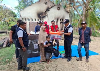 Ketua PMI Aceh Utara, H. Tantawi, SIP, MAP, didampingi jajaran pengurus dan relawan menyerahkan bantuan logistik serta perlengkapan kepada Dahliana, ibu lima anak asal Gampong Cot Laba, Baktiya Barat