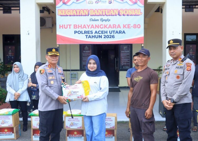 Kapolres Aceh Utara AKBP Trie Aprianto menyerahkan paket sembako kepada salah seorang pekerja harian lepas (PHL) saat menggelar aksi sosial di Mapolres Aceh Utara, Lhoksukon