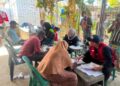 Relawan KSR PMI Unit 08 UIN SUNA Lhokseumawe mendampingi penyaluran bantuan shelter toolkit kepada penerima manfaat program pemulihan pascabencana di Kecamatan Sawang, Kabupaten Aceh Utara