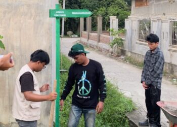Mahasiswa KKN-PPM Kelompok 29 Unimal memasang plang nama lorong di Desa Cempeudak, Kuta Makmur, Aceh Utara, Rabu (26/8/2026). Pemasangan ini dilakukan untuk memudahkan navigasi serta pencarian alamat bagi warga setempat dan pendatang