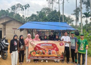 Mahasiswa KKN Kelompok 39 Unimal memasang spanduk promosi UMKM warga di Desa Sido Muliyo, Kutamakmur, Aceh Utara