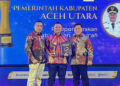 Bupati Aceh Utara, Ismail A. Jalil (Ayahwa), menerima penghargaan Serambi Award 2026 kategori "Pelopor Gerakan Membumikan Al-Qur'an" dari Pemred Serambi Indonesia Zainal Arifin M. Nur dan Pemimpin Perusahaan Firdaus D. di Gedung AAC Dayan Dawood, Banda Aceh