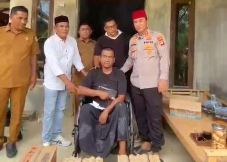 Kepala Sekretariat Baitul Mal Aceh Utara, Samsul Bahri bersama Kapolres Lhokseumawe dan unsur DPRK menyerahkan bantuan kursi roda kepada Abdullah (46), warga penderita stroke di Gampong Blang Dalam, Nisam
