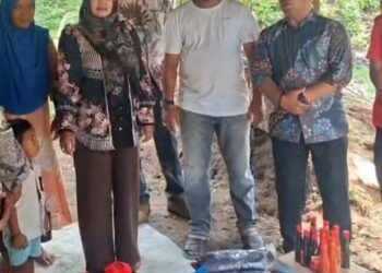 Ketua TP PKK Aceh Utara Musliana Ismail A. Jalil dan Kepala Sekretariat Baitul Mal Samsul Bahri menyerahkan bantuan kepada keluarga Usman Puasa di Gampong Cot Mee, Kecamatan Nisam