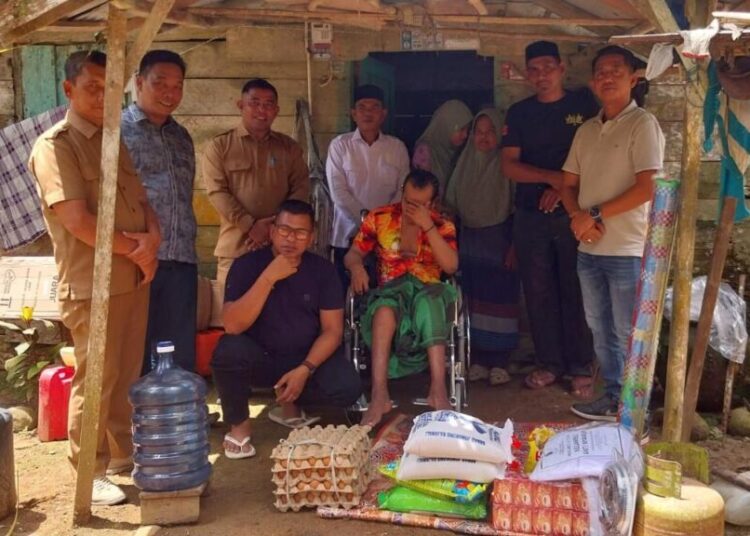 Rombongan Baitul Mal dan anggota DPRK Aceh Utara saat menyerahkan bantuan kursi roda serta sembako kepada M. Yakop (72), penderita stroke menahun di Gampong Teupin Rusep, Kecamatan Sawang