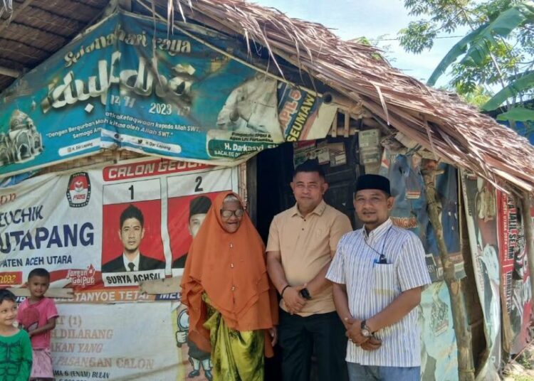 Kepala Sekretariat Baitul Mal Aceh Utara, Samsul Bahri, meninjau gubuk berdinding spanduk bekas milik Khalidah (57) di Gampong Keutapang, Tanah Pasir, Sabtu (3/10/2026). Gubuk tersebut akan segera dirombak menjadi rumah layak huni.