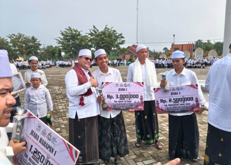 Bupati Aceh Utara, Ismail A Jalil (Ayahwa), menyerahkan hadiah kepada santri pada Peringatan Hari Santri Nasional (HSN) 2026 di Lapangan Upacara Kantor Bupati, Lhoksukon, Kamis (22/10/2026)